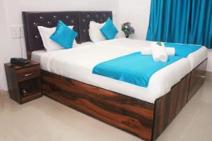 a bedroom with a large bed with blue and white pillows at Sadanand Home in Navi Mumbai