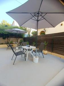 a patio with a table and two chairs and an umbrella at Chris Apartments Corfu - Studio without kitchen in Alepou