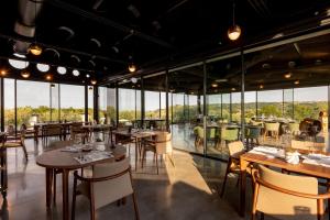 a restaurant with tables and chairs and large windows at TEMA Relais - Tenuta Masciangelo in Francavilla al Mare