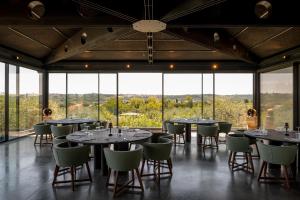 a dining room with tables and chairs and large windows at TEMA Relais - Tenuta Masciangelo in Francavilla al Mare