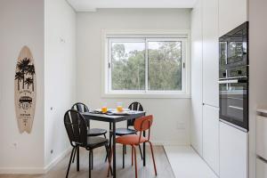 オバールにあるFuradouro Pine & Sea with Swimming Pool Studio 1のテーブルと椅子と窓のあるダイニングルーム