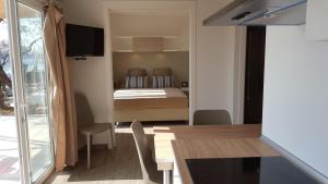 a room with a bed and a table and chairs at Baia Holiday Gardasee in Moniga