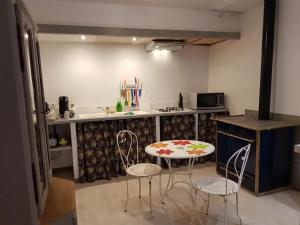 een keuken met een tafel en stoelen in een keuken bij Studio moderne à Montagnac-Montpezat - 32 m² tranquille in Montagnac