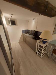 a small kitchen with a table and a lamp at Appartement moderne à Gréolières, 26 m², vue saisissante in Gréolières