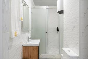 a white bathroom with a shower and a sink at Cozy Hotel 华谊酒店 in Bishkek +37 photos