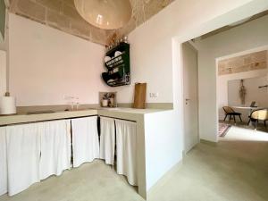 a kitchen with white counters and a dining room at Terrazza De Palma, Vista e Relax in Monopoli +17 photos