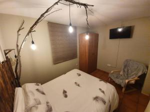 a bedroom with a bed and a chair and lights at Paraíso Desconocido 4 La Leyenda del Curavacas in Alba de los Cardaños