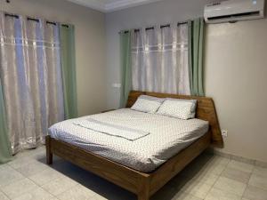 a bed sitting in a room with windows at Villa moderne Lawsmat in Lomé
