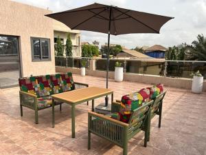 two chairs and a table with an umbrella on a patio at Villa Lawsmat avec piscine privée et grand jardin in Lomé