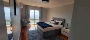 ein Schlafzimmer mit einem Bett mit Blick auf das Meer in der Unterkunft Radiantescapadela in Estreito da Calheta