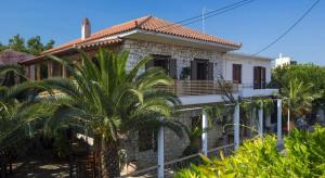 a house with palm trees in front of it at Ikia Luxury Homes in Gonia