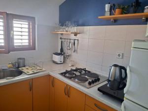 a kitchen with a stove top and a sink at Apartment Patricia in Primošten