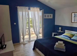 a blue bedroom with a bed and a sliding glass door at Apartment Patricia in Primošten