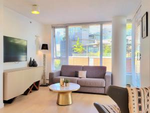 a living room with a couch and a table at Beautiful 1 BR in the Heart of Downtown: Parking, Pool & Gym in Vancouver