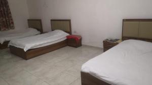 a room with two beds and two night stands at سكنات قصر الياسمين in Ḩayl Āl ‘Umayr