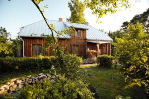 a wooden house with a metal roof at Atomi in Aucugals