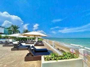 a beach with chairs and umbrellas and the ocean at Aria Vũng Tàu Hotel & Resort - Căn hộ và biệt thự nghỉ dưỡng in Xa Thang Nhut
