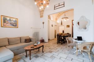 un soggiorno con un divano e un tavolo di Dimora Tizzi - Boutique Apartment - By Just Houses SRL ad Alessano