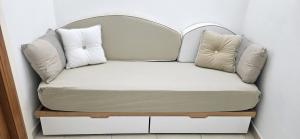 a couch with two pillows on top of it at Nonna Rosa House - Cozy Apartment - Molfetta in Molfetta