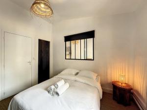 una camera da letto con due letti e una finestra di Cosy Appartement, St Sebastien a Lione 1 altra foto