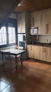 eine Küche mit Tisch und Stühlen in einem Zimmer in der Unterkunft Casa Rural Cuatro Vientos in Santiago-Pontones