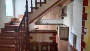 eine Küche mit Treppe und eine Küche mit Hockern in der Unterkunft Casa Rural Cuatro Vientos in Santiago-Pontones