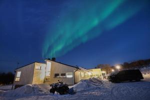 a building with the aurora in the sky at Varangertunet bed & breakfast in Jakobselv
