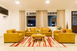 a living room with two couches and a coffee table at Sagrados Corações - Pousada in Pindamonhangaba