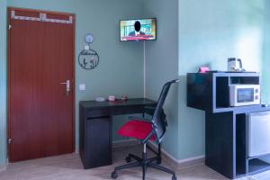 a room with a desk and a chair and a microwave at Gemütliches Zimmer im Stuttgart Flughafen Messe in Ostfildern