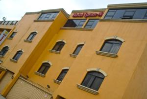 a yellow building with windows and a sign on it at Hotel Ipsan Nah in La Esperanza