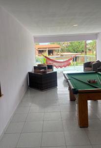 a living room with a pool table and a hammock at Wcasadepraia in Maragogi