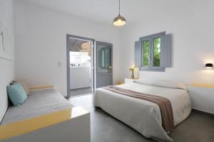 una camera da letto bianca con un letto e una finestra di Aegean Studios Perissa a Perissa