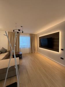 a living room with a bed and a flat screen tv at Massif Carpathian Call in Poiana Brasov