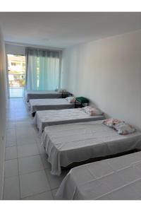 a row of beds lined up against a wall at Wcasadepraia in Maragogi