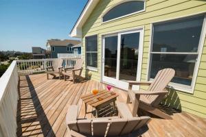 una terraza con 2 sillas y una mesa en una casa en Endless Summer Nights, en Waves