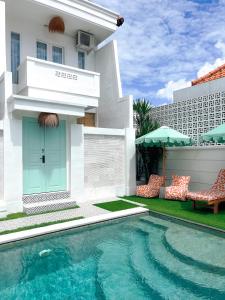 a house with a swimming pool in front of a building at Kaktus Boutique Apartments Bali - ADULTS ONLY in Legian