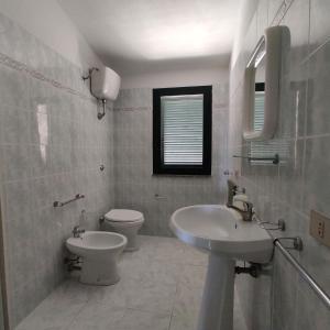 a bathroom with a sink and a toilet at Residenza Agnese Sardegna in La Ciaccia