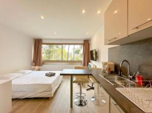 een slaapkamer met een bed en een keuken met een wastafel bij Studio Moderne Cannes - Parking - Proche de la plage in Cannes