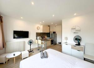 een slaapkamer met een wit bed en een keuken bij Studio Moderne Cannes - Parking - Proche de la plage in Cannes