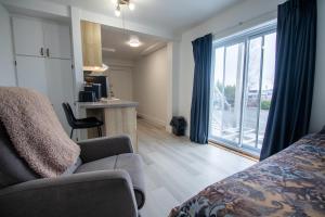 a room with a bed and a kitchen with a window at Appartements-Hôtel les Mouettes in Sept-Îles +8 photos