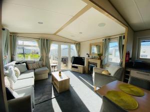 a living room with a couch and a table at RJ Luxury caravan hire 2 with Hot Tub in Tattershall