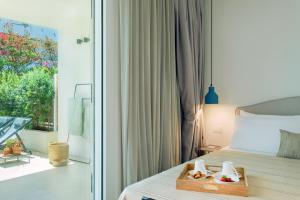 a bedroom with a bed with a tray of food on it at Domìa Boutique Hotel e Cucina in Mondello