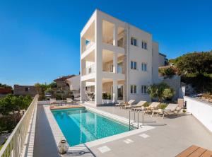 an apartment with a swimming pool and a building at Villa Porto in Ražanj
