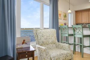 un soggiorno con sedia, tavolo e finestra di Sunset Bay Villa 118 - Waterfront, Deep-water boat slip! a Chincoteague