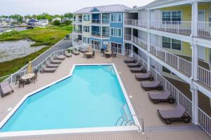 un balcone dell'appartamento con piscina e mobili da giardino di Sunset Bay Villa 118 - Waterfront, Deep-water boat slip! a Chincoteague