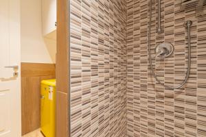 a bathroom with a shower with brown tiles at La SuiteDellAvvocato in Naples