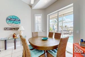 Un comedor con mesa y sillas de madera. en Villa Kelleigh Anne, en Cabo Coral
