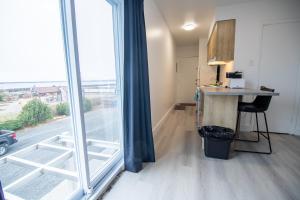 a room with a desk and a large window at Appartements-Hôtel les Mouettes in Sept-Îles