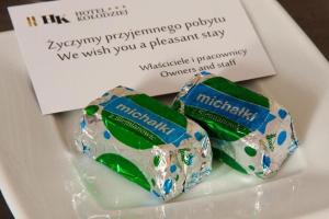 two chocolate wrappers on a plate with a card at Albergo KOLODZIEJ in Siemianowice Śląskie