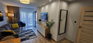 a living room with a couch and a mirror at APARTAMENT MARZENA in Świnoujście